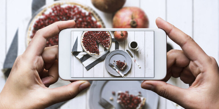 person taking picture of food with smartphone