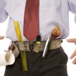 Man with an office supply tool belt marker coffee mug ruler scissors