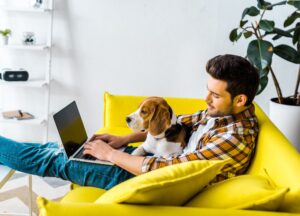 Man sitting on couch working on computer