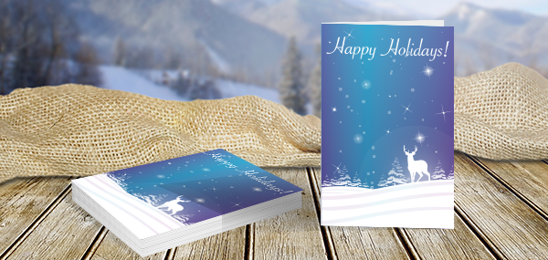 Stack of folded holiday cards with blue snow landscape design 