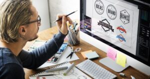 Designer on the computer using brand guidelines to create an on-brand logo for a company